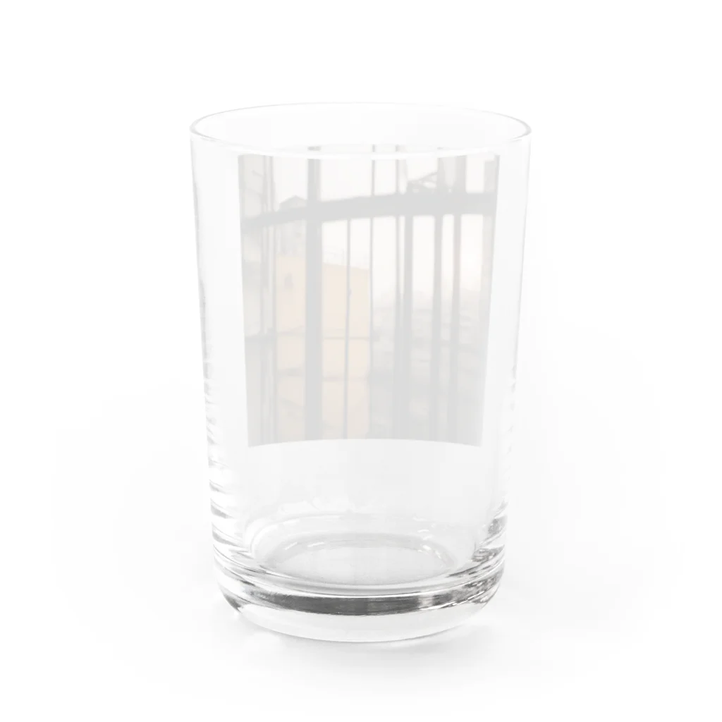 shell_hutの窓から覗く荒廃した建物が立ち並ぶ無人の通り Water Glass :back